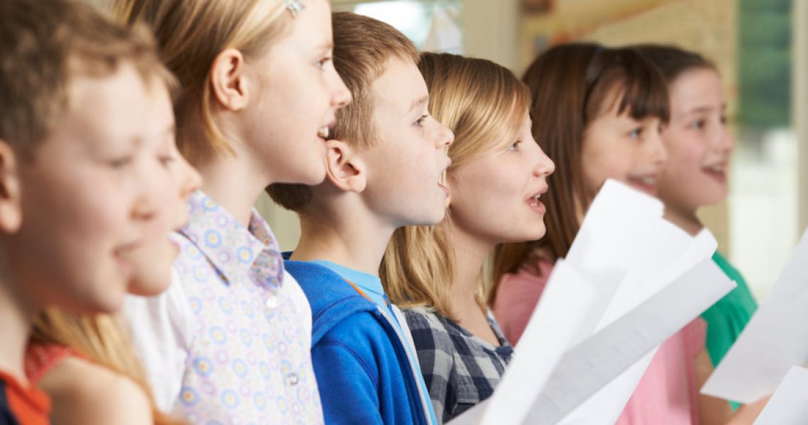 Group Of School Children Singing In School Choir